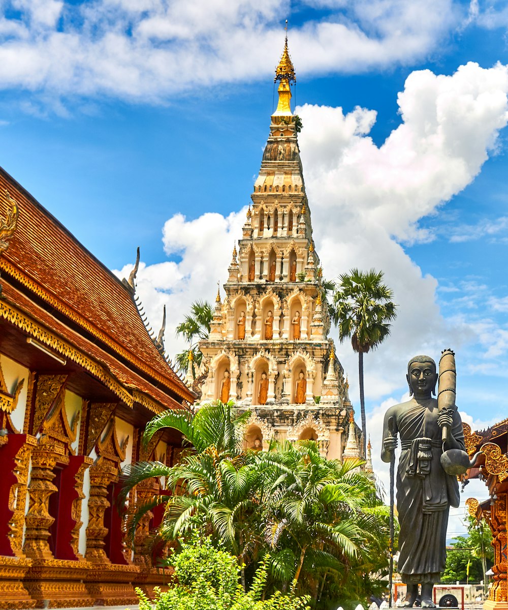 A golden Thai temple spire under a bright blue sky in Thailand